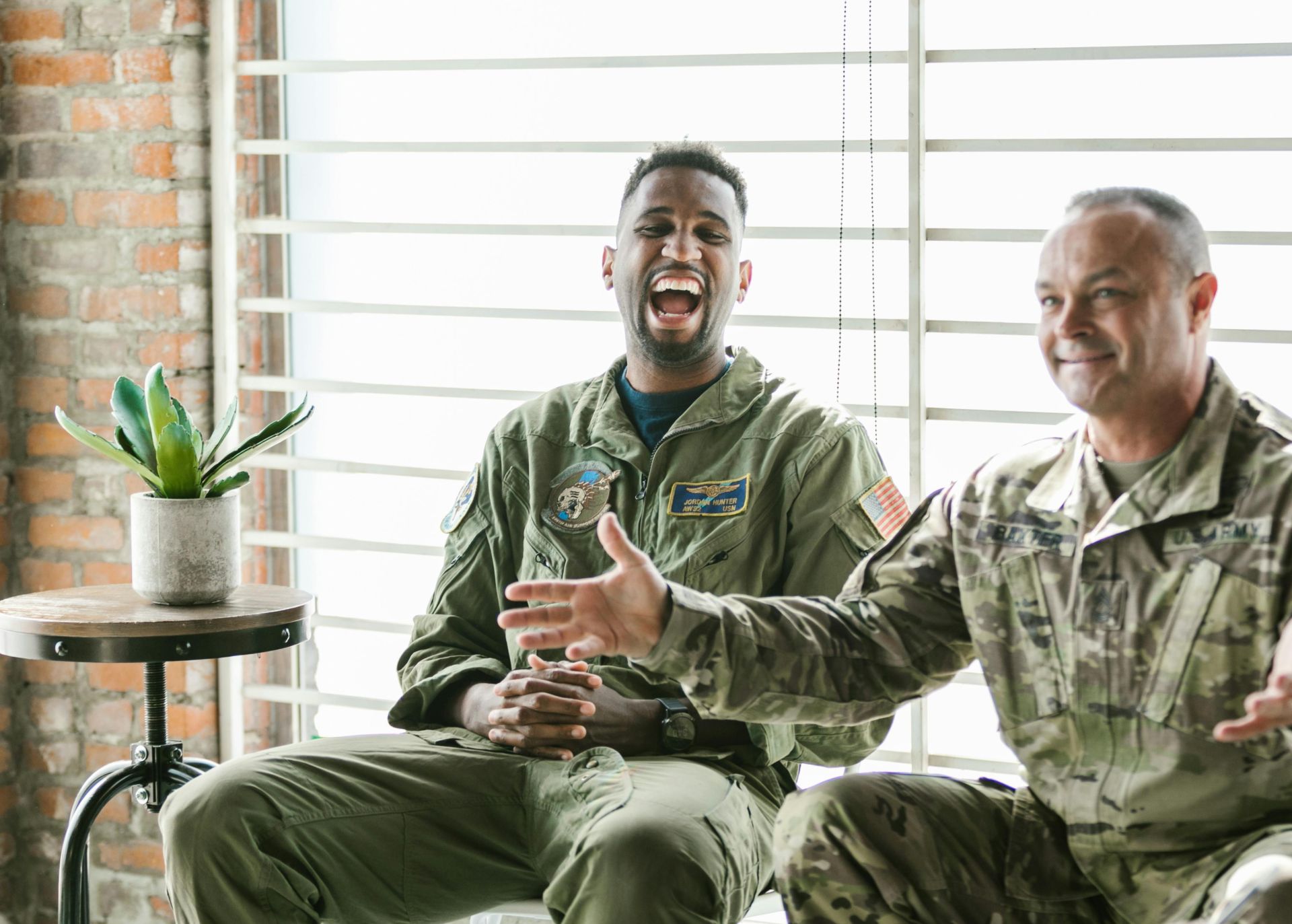Two soldiers in therapy session, laughing and engaging, highlighting mental health support.